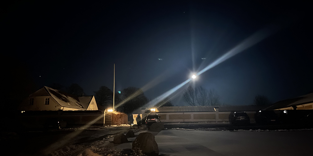 Essens Gaarden i mørket med lys og oplyst nattehimmel.